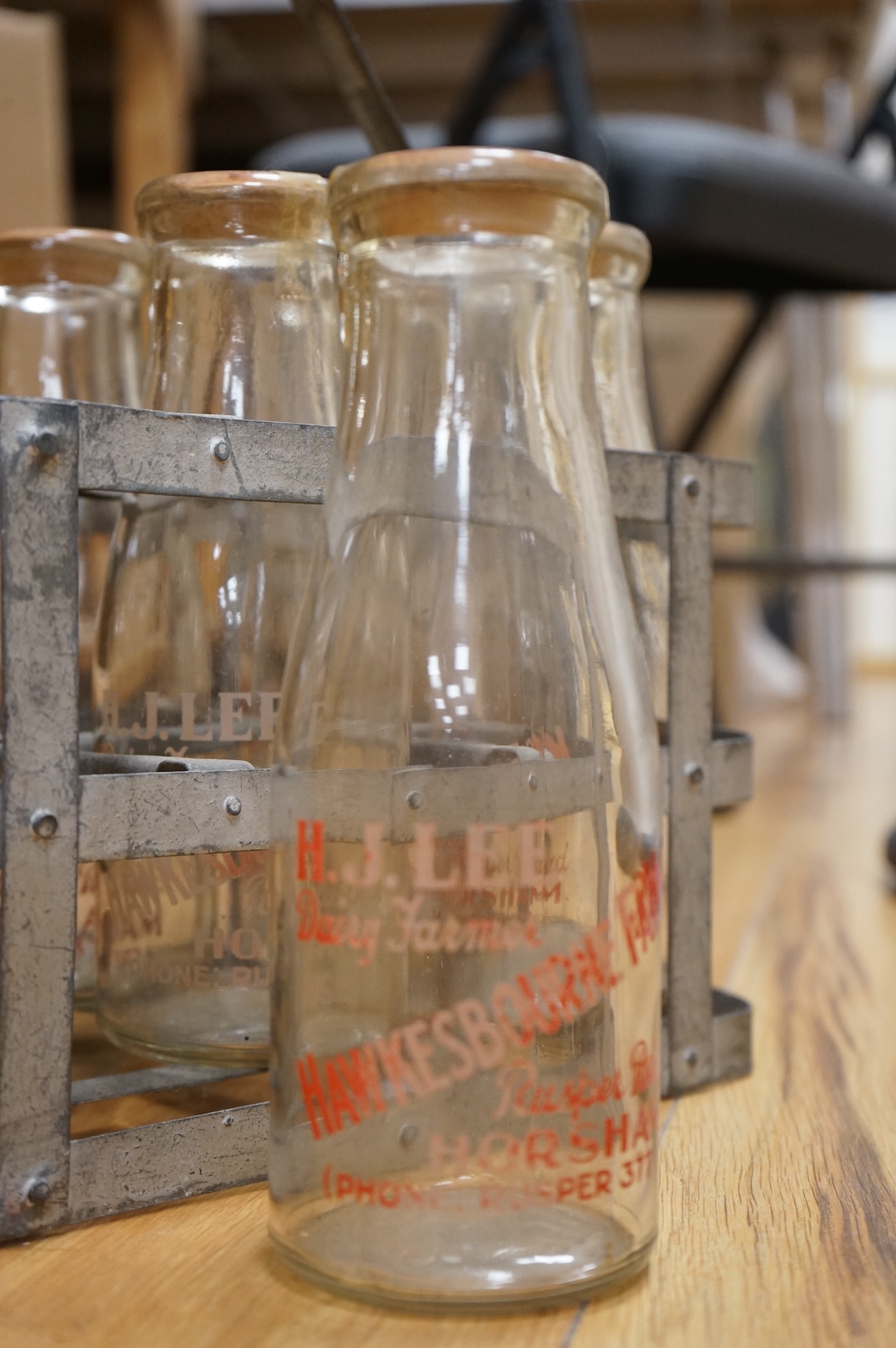 A vintage metal crate of six H J Lee, Horsham milk bottles